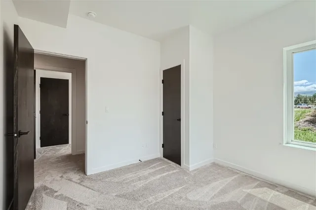a view of a wooden house with a yard and sitting area