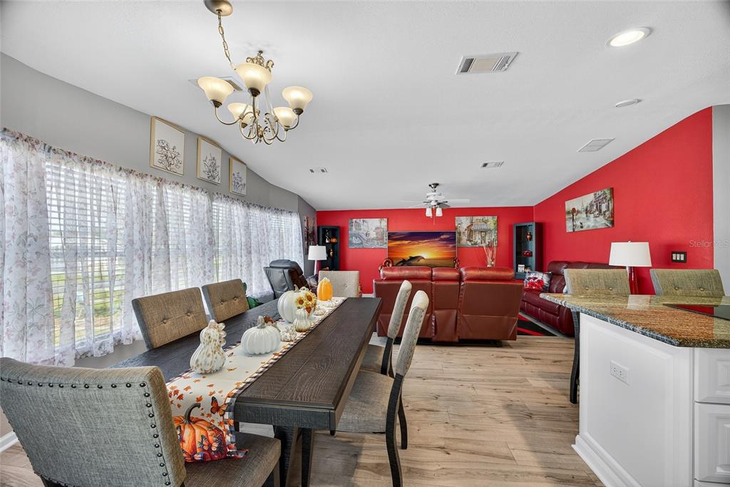 29221 Orangewood Street Punta Gorda, FL 33982 - Photo 3 of 38 a view of a dining room with furniture a chandelier and wooden floor