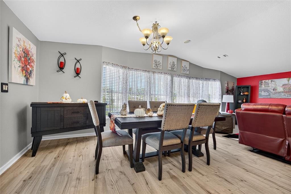 29221 Orangewood Street Punta Gorda, FL 33982 - Photo 7 of 38 a view of a dining room with furniture a chandelier and wooden floor