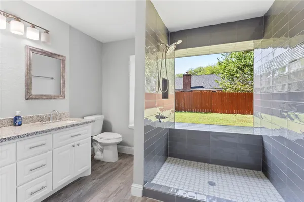 a bathroom with a granite countertop sink a toilet and a bathtub
