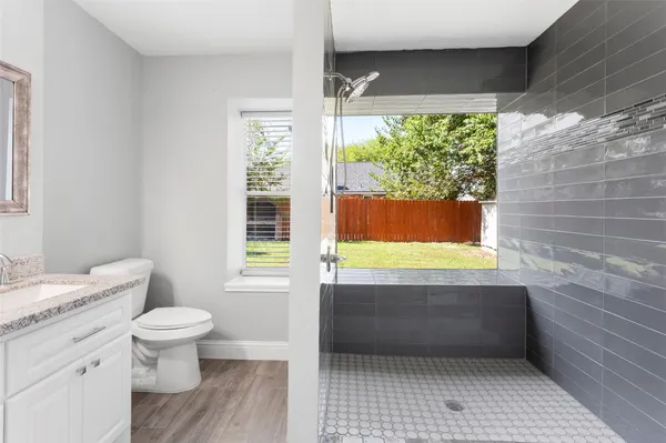 a bathroom with a granite countertop toilet a sink and a bathtub