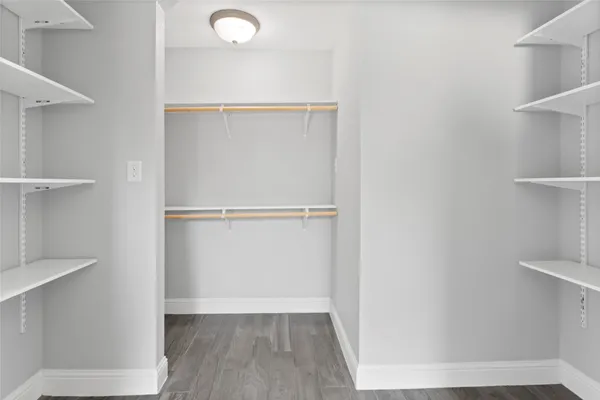 a view of walk in closet with empty racks