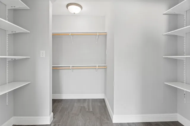a view of walk in closet with empty racks