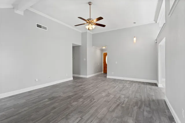 a view of a livingroom with a ceiling fan and wooden floor