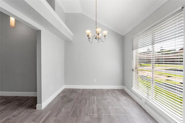 a view of a room with wooden floor and a window