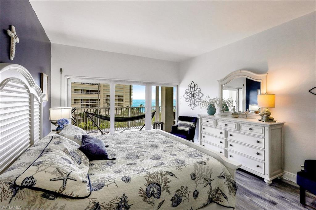 1 Bluebill Avenue, Unit 803 Naples, FL 34108 - Photo 13 of 19 a large bedroom with a bed a dresser and mirror