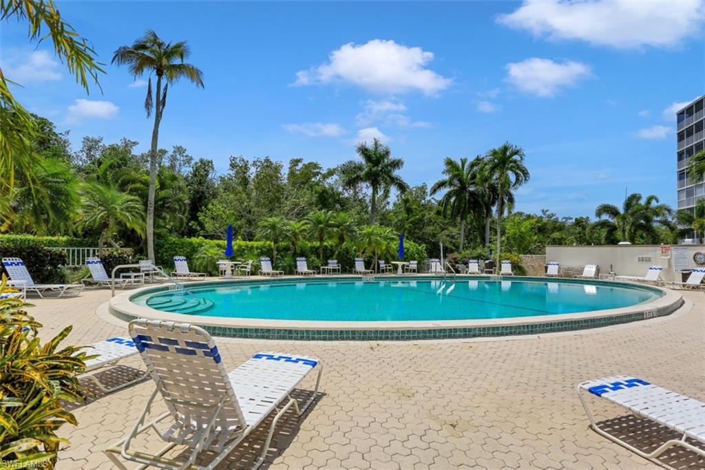 1 Bluebill Avenue, Unit 803 Naples, FL 34108 - Photo 19 of 19 a view of a swimming pool with a yard and plants