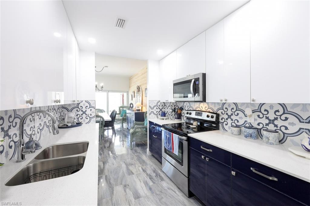 1 Bluebill Avenue, Unit 803 Naples, FL 34108 - Photo 10 of 19 a kitchen with stainless steel appliances granite countertop a stove and a sink