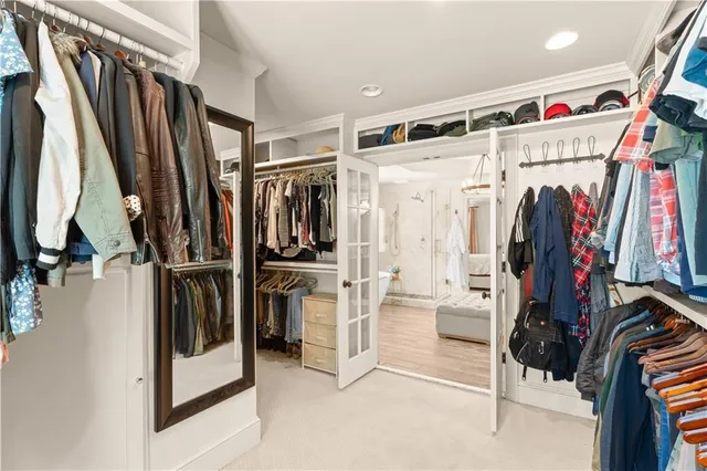 a view of walk in closet with clothes and shoes