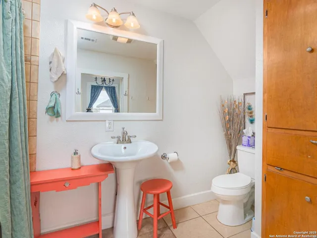 a bathroom with a toilet a sink and a mirror