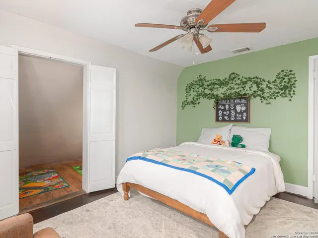 a bedroom with a bed and a painting on the wall