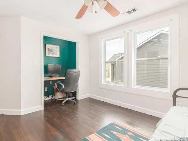 a view of a workspace with furniture and a window