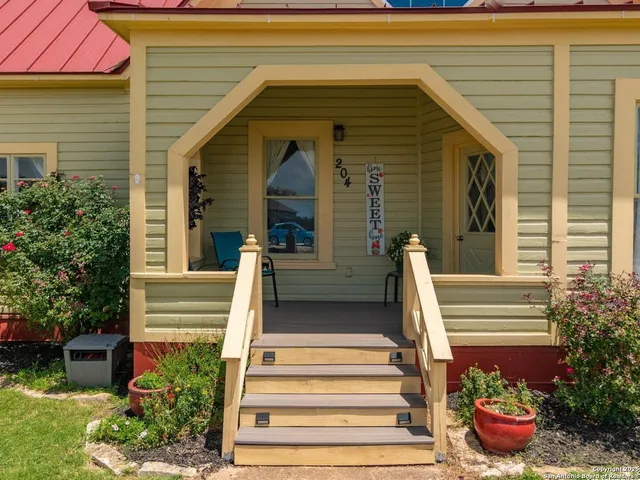 a front view of a house with potted plants