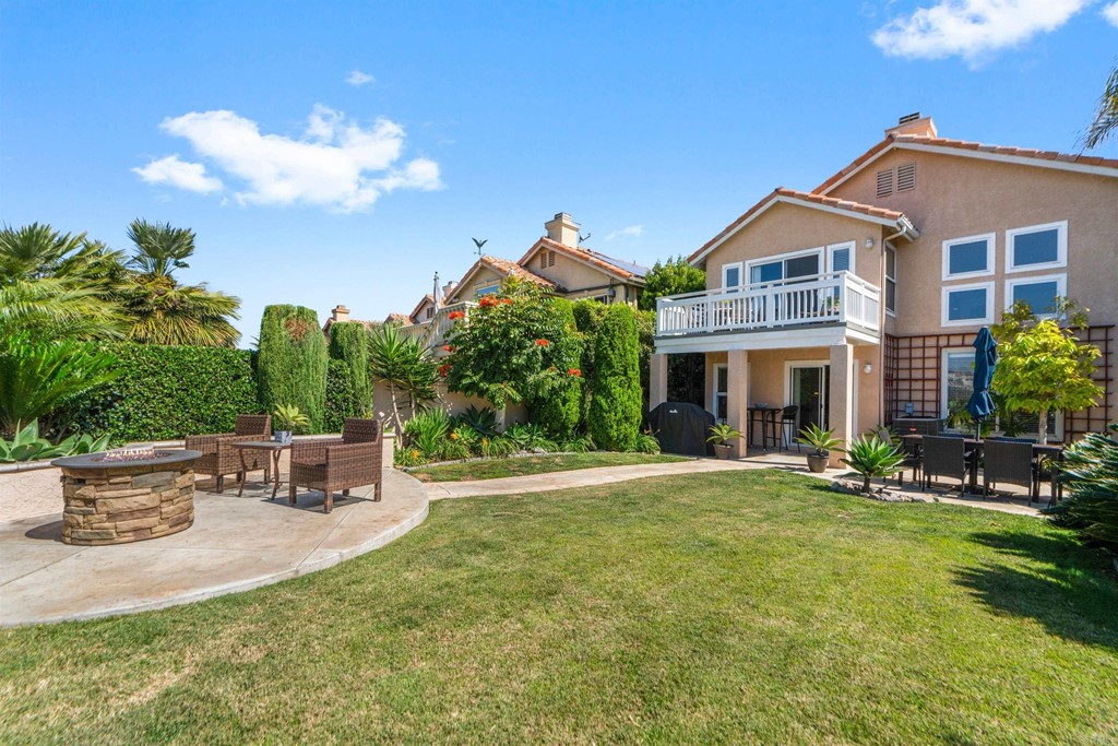 7 Monaco Dana Point, CA 92629 - Photo 27 of 32 a view of a white house with a yard and table and chairs under an umbrella