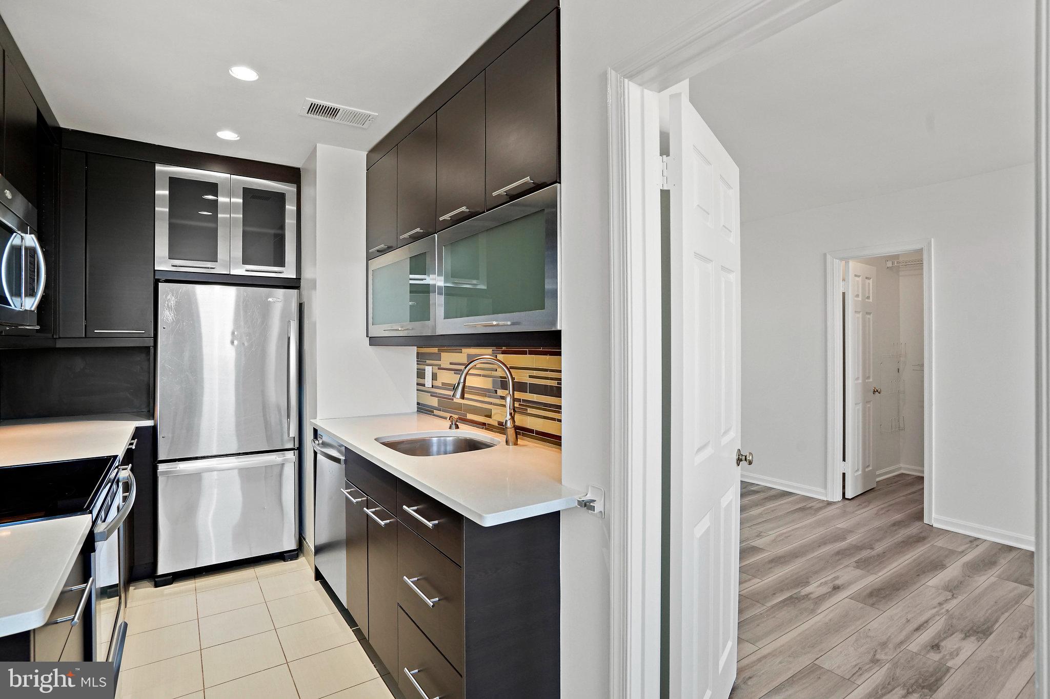 1920 S Street Northwest, Unit 804 Washington, DC 20009 - Photo 15 of 25 a kitchen with stainless steel appliances granite countertop a refrigerator and a sink