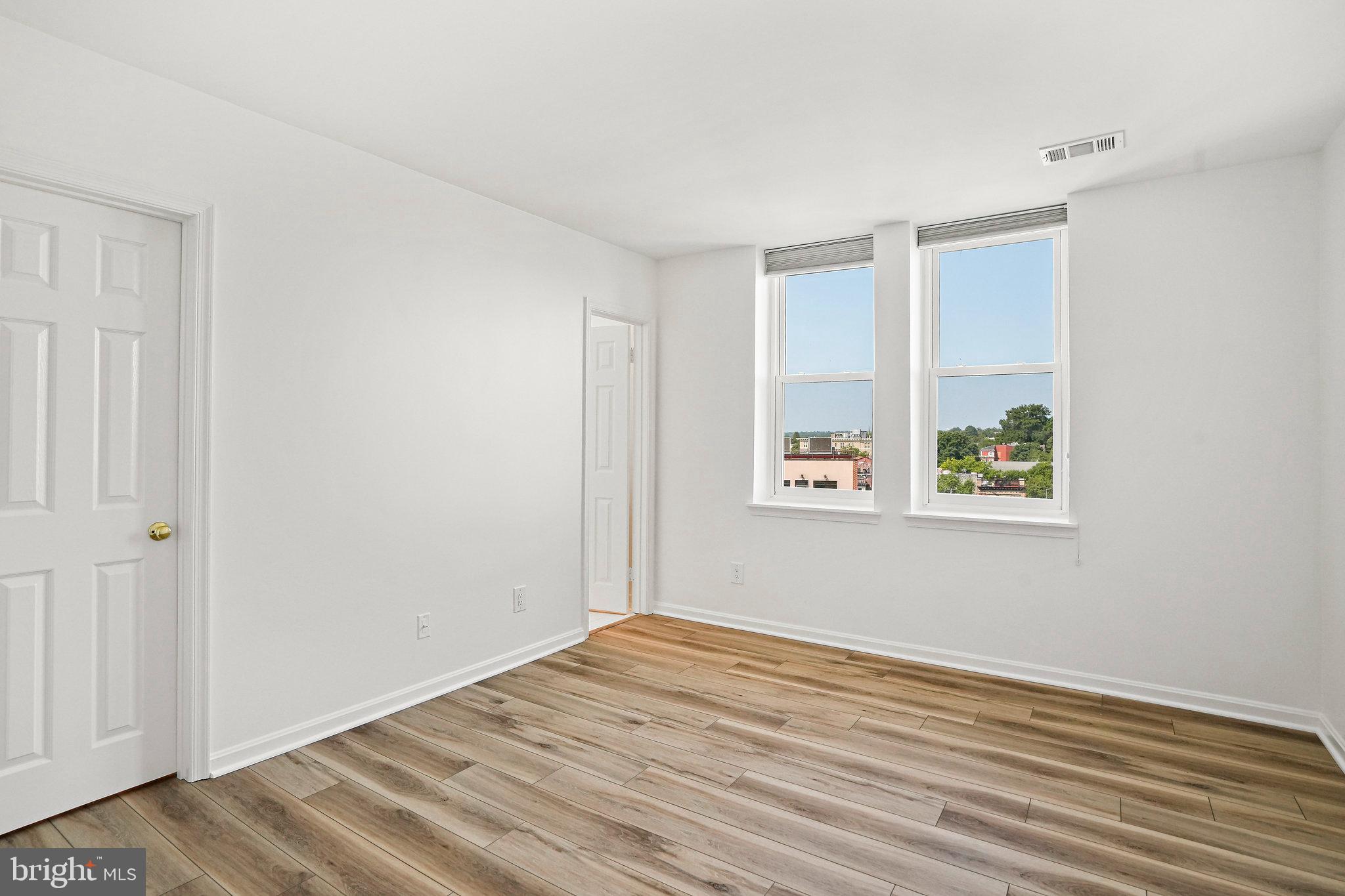 1920 S Street Northwest, Unit 804 Washington, DC 20009 - Photo 22 of 25 a view of an empty room with wooden floor and a window
