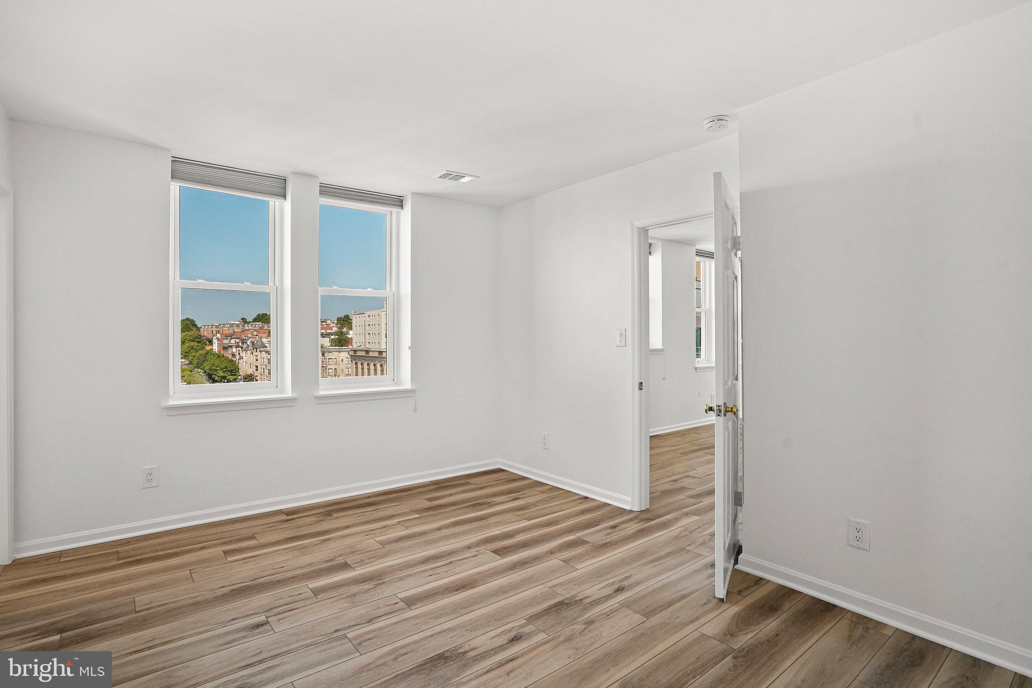 1920 S Street Northwest, Unit 804 Washington, DC 20009 - Photo 24 of 25 an empty room with wooden floor and windows