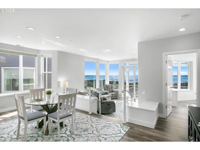 a living room with furniture large window and wooden floor