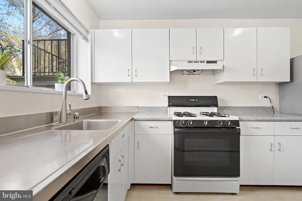 a kitchen with white cabinets and white appliances