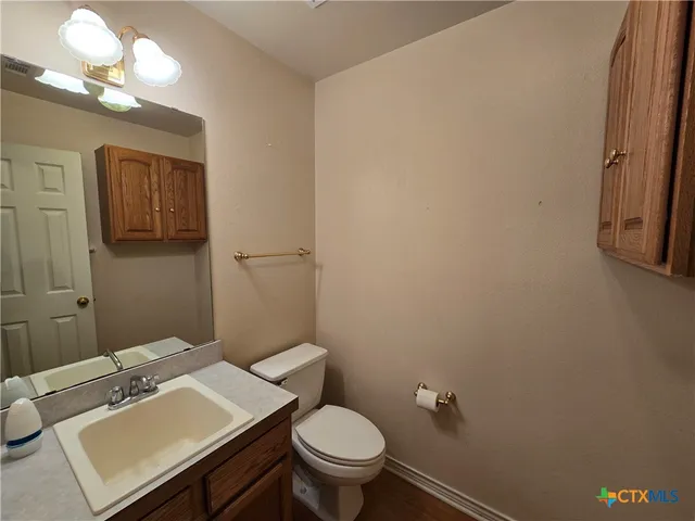 a bathroom with a sink a toilet and a mirror