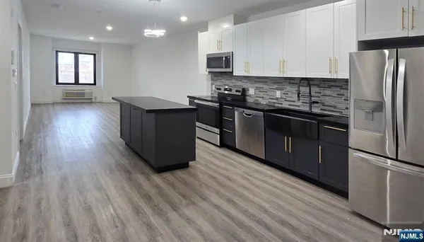 a kitchen with stainless steel appliances granite countertop a stove a refrigerator and a microwave