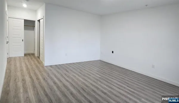 a view of a big room with wooden floor and windows