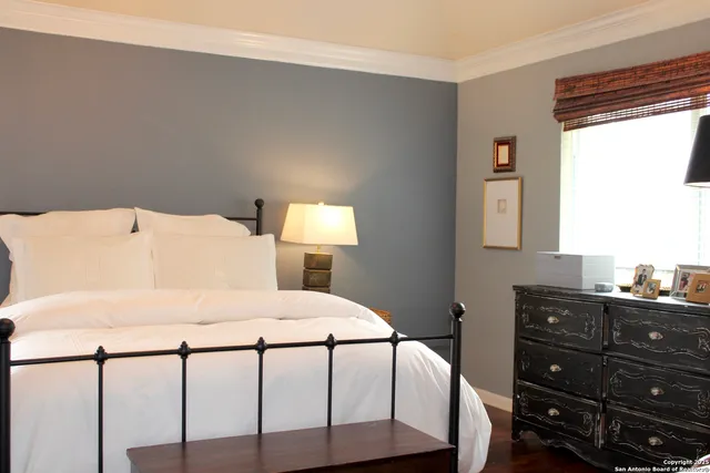 a bedroom with a bed a dresser and a window