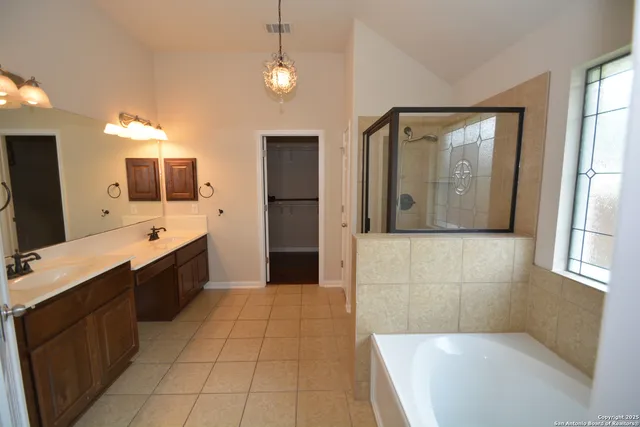 a large bathroom with a large mirror vanity and shower