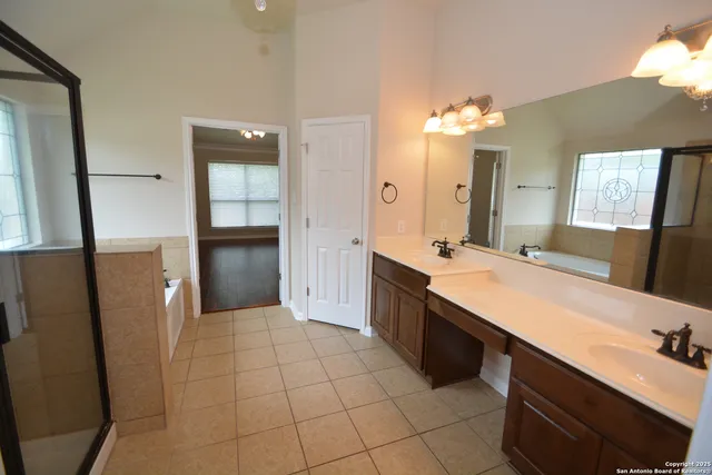 a large bathroom with a double vanity sink a mirror and a shower