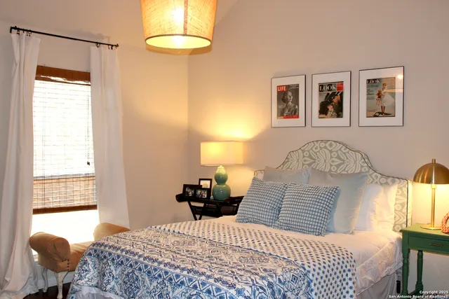 a bedroom with a bed and dresser with wooden floor