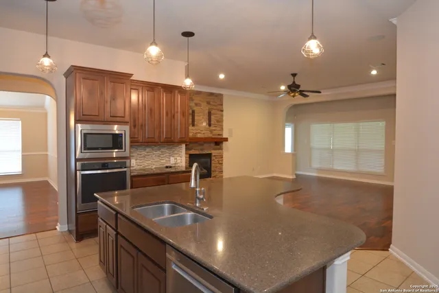 a kitchen with kitchen island a sink stainless steel appliances and cabinets