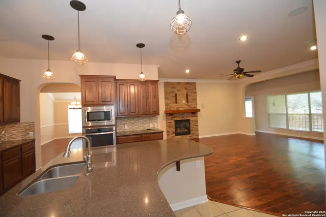 a open kitchen view with stainless steel appliances a large center island and living room view