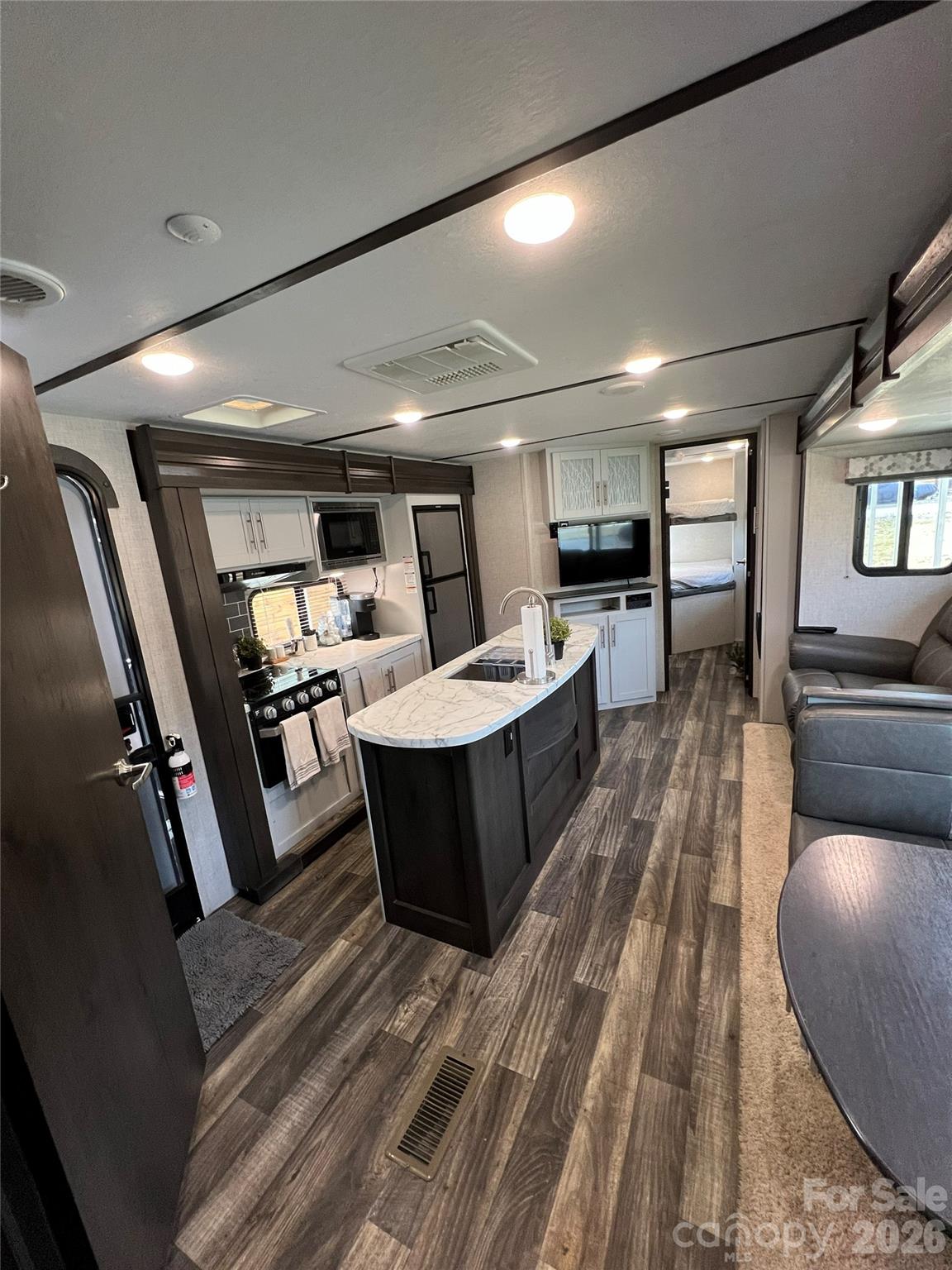 415 Hyde Road, Unit 24 Robbinsville, NC 28771 - Photo 21 of 47 a living room with couches and kitchen view with wooden floor