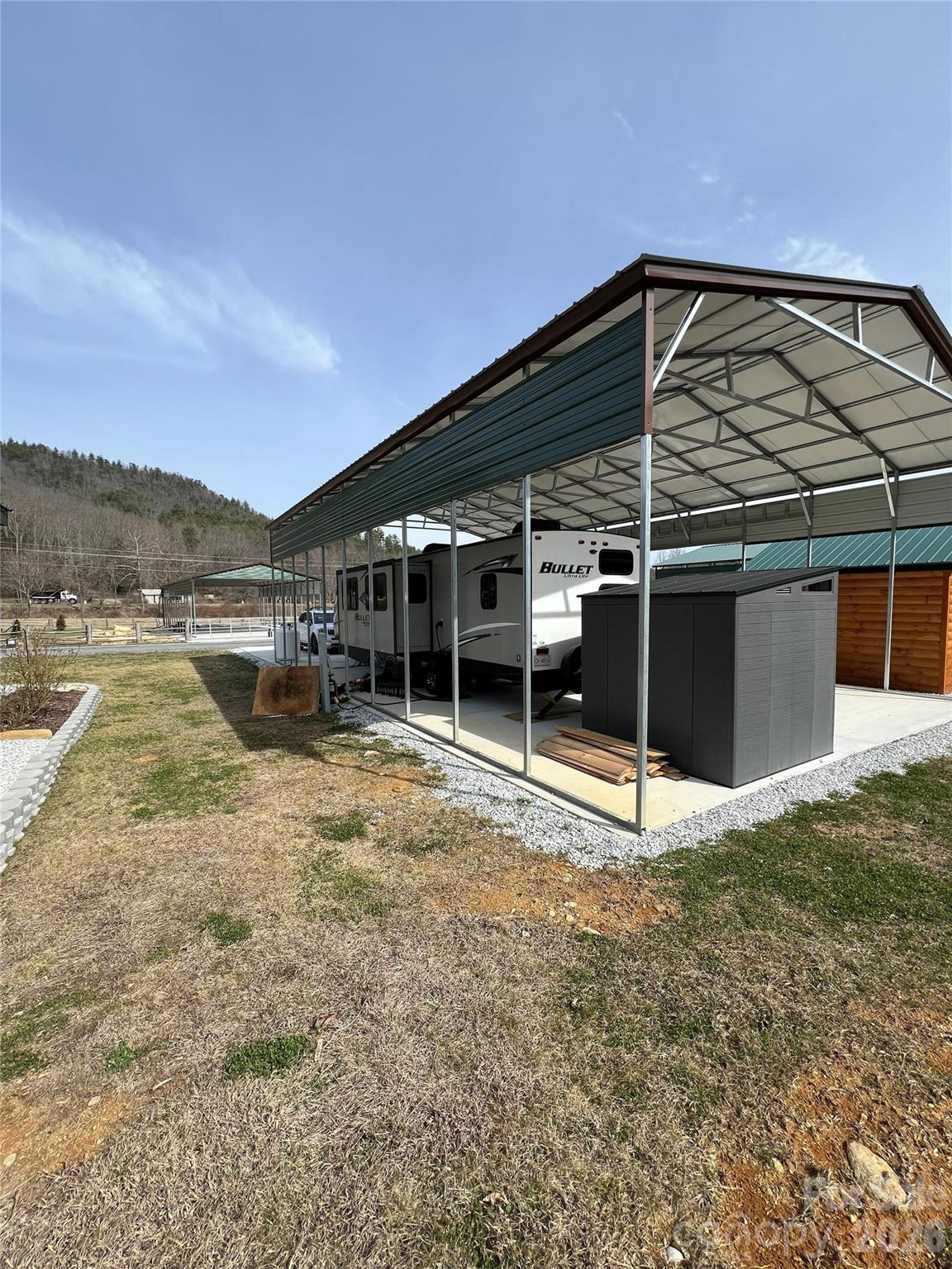 415 Hyde Road, Unit 24 Robbinsville, NC 28771 - Photo 38 of 47 a view of a house with backyard and trees in the background