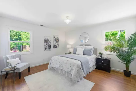 a spacious bedroom with a bed and a potted plant
