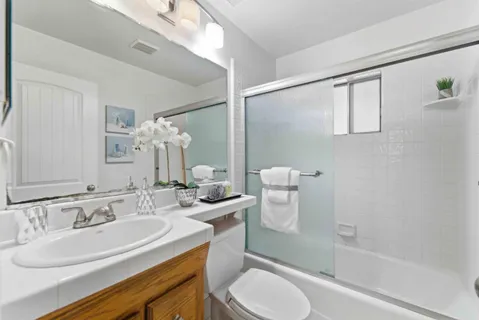 a bathroom with a granite countertop sink toilet and shower