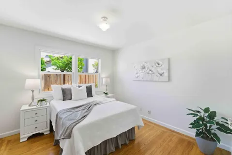 a bedroom with a bed and a potted plant