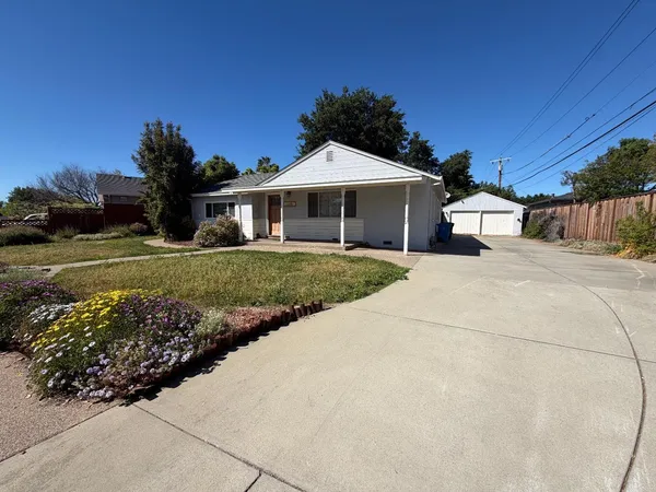 a view of a house with a yard and potted plants