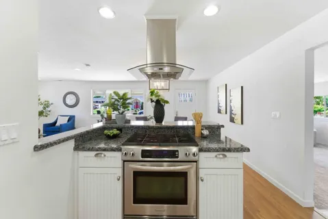 a kitchen with stainless steel appliances granite countertop a stove and a sink