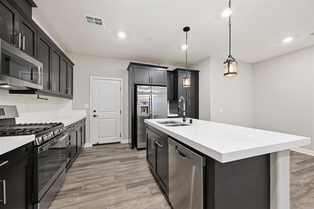 1118 Delpy View Vista, CA 92084 - Photo 11 of 32 a kitchen with a stove a sink and wooden floor