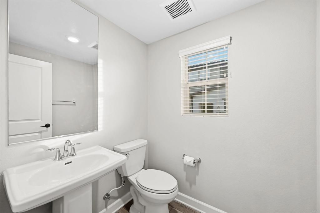 1118 Delpy View Vista, CA 92084 - Photo 13 of 32 a bathroom with a sink a toilet and a mirror