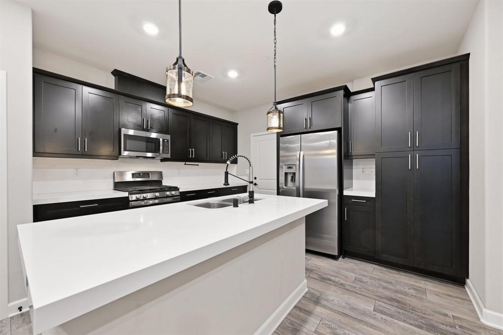 1118 Delpy View Vista, CA 92084 - Photo 8 of 32 a kitchen with stainless steel appliances a refrigerator sink and microwave