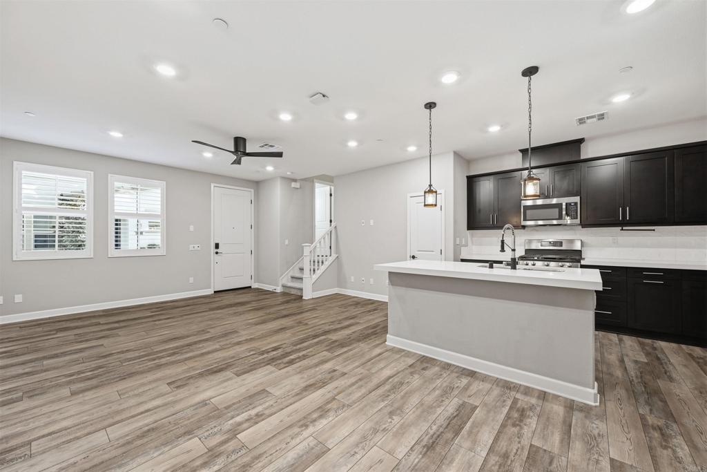 1118 Delpy View Vista, CA 92084 - Photo 10 of 32 a large kitchen with kitchen island granite countertop a large counter top stainless steel appliances and cabinets
