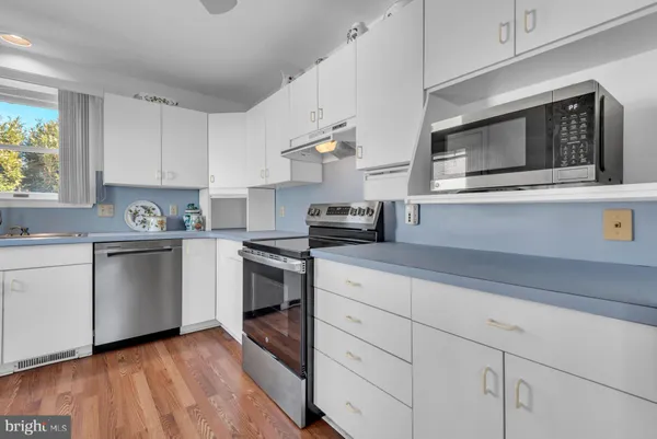 a kitchen with granite countertop white cabinets and white appliances