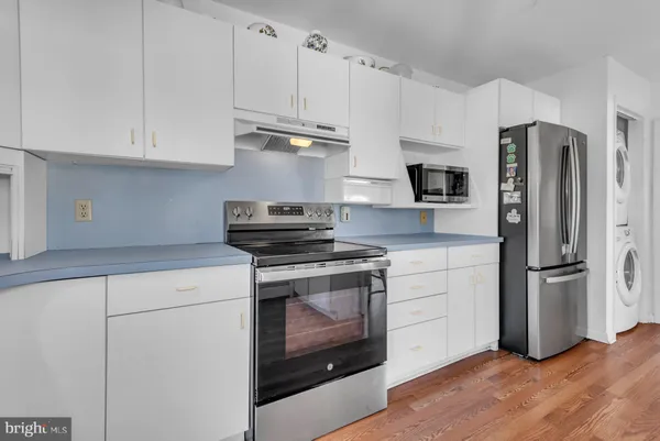 a kitchen with stainless steel appliances white cabinets and a refrigerator