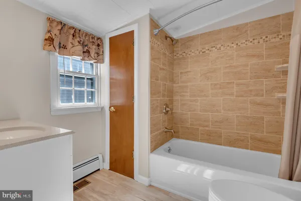 a bathroom with a tub shower and sink