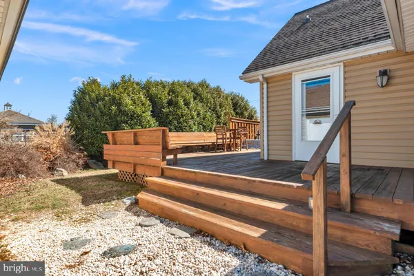 a view of house with wooden deck and a sitting space