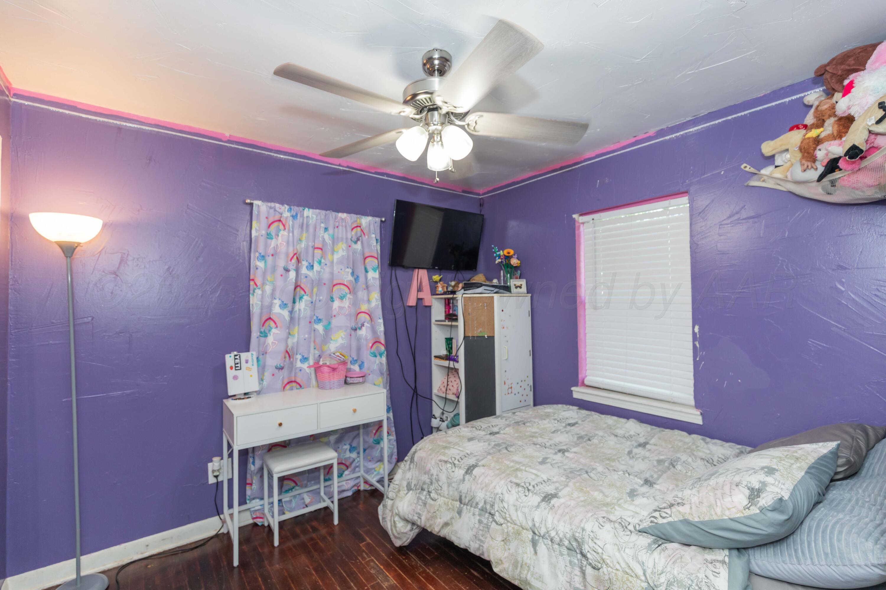 4624 South Travis Street Amarillo, TX 79110 - Photo 13 of 24 a bedroom with a bed and a chandelier