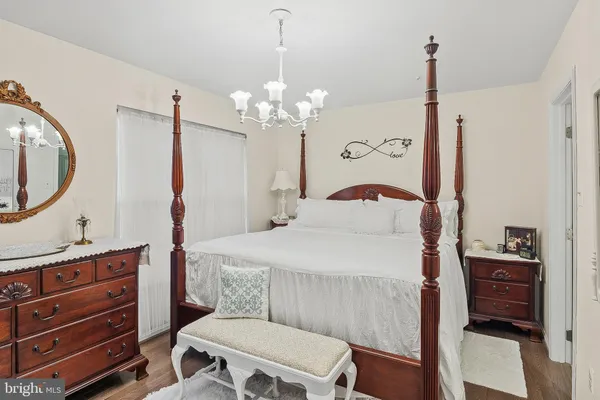 a bedroom with a bed a dresser and potted plants