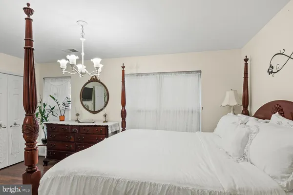 a bedroom with a bed a mirror and a window